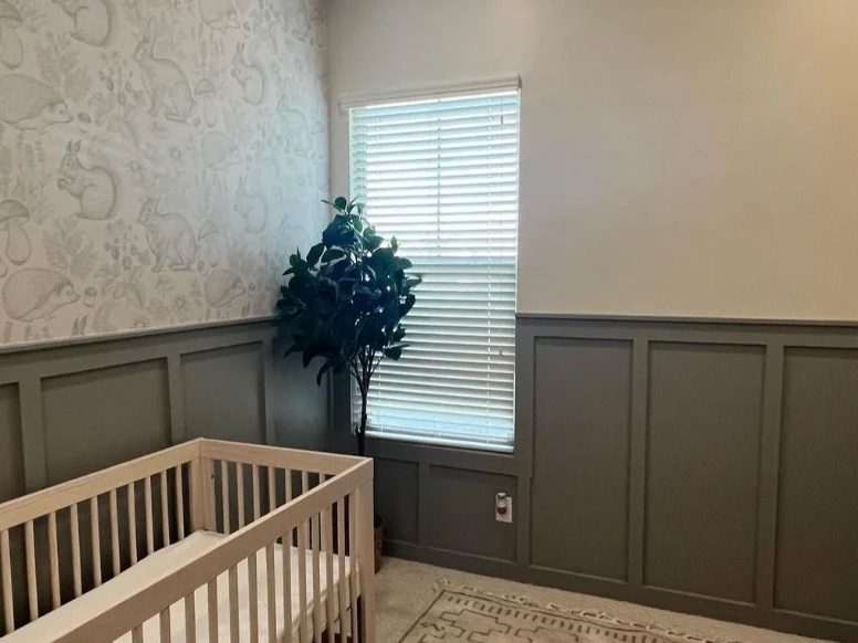 After: nursery with wallpaper above gray paneled wainscoting