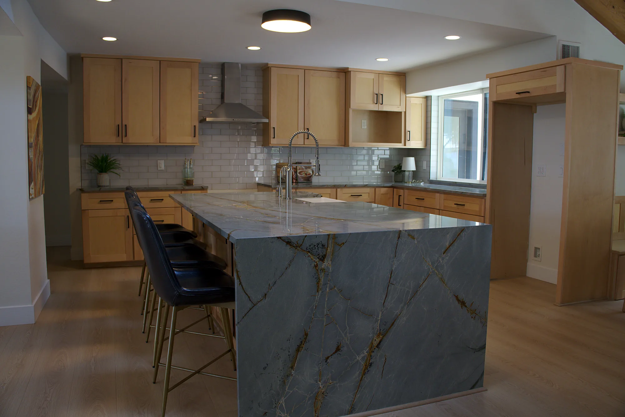 Kitchen with a waterfall island and bar stools, finished after a contractor takeover in Phoenix