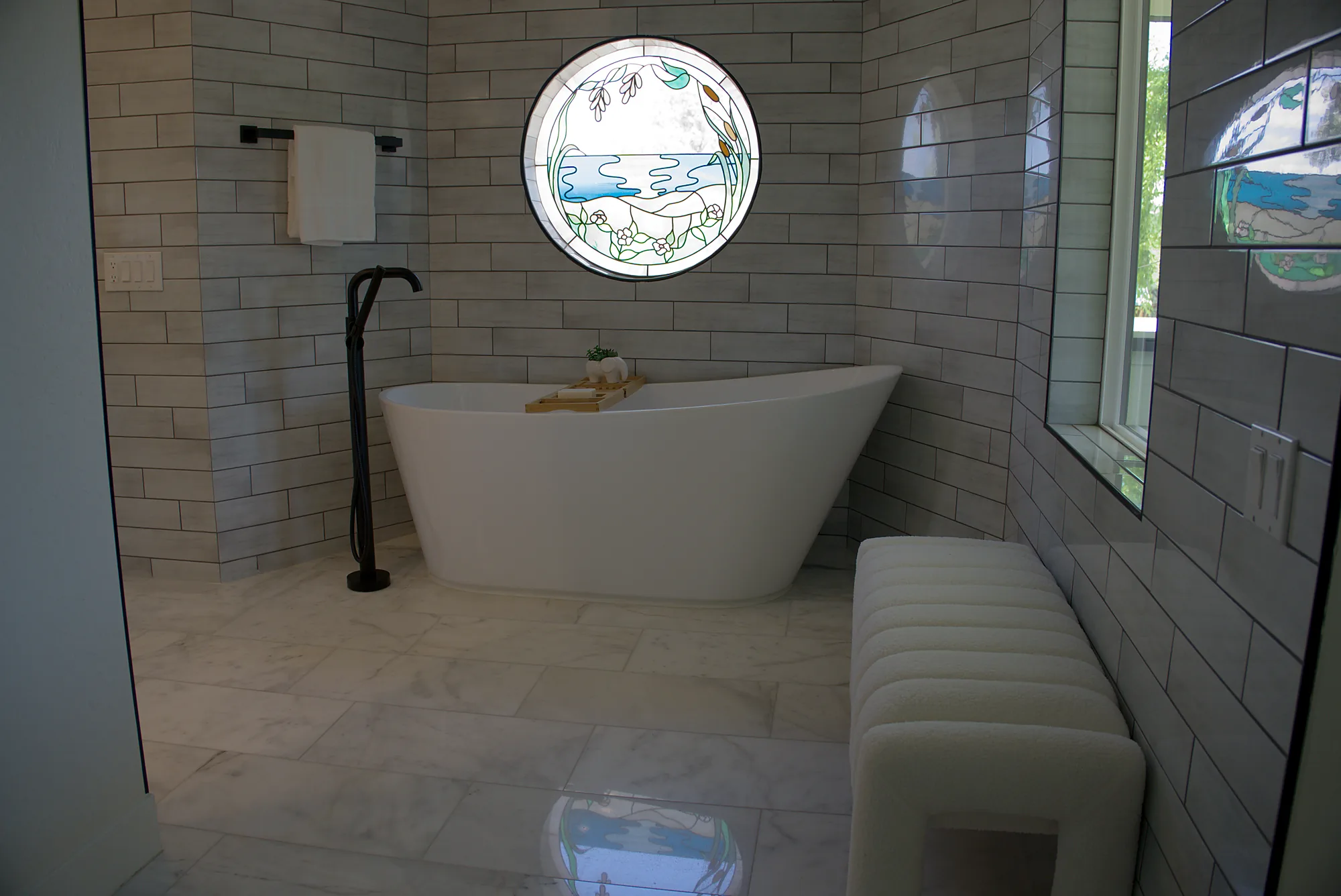 Freestanding tub under a round stained glass window
